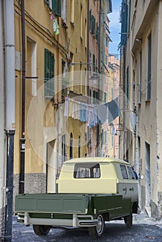 Old van with load bed in a narrow alley or lane