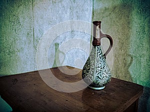 Old vase on a wooden table.