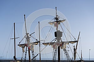 Old vessel boat wooden masts, folded white sails