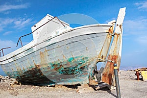Old veteran ruined fishing boat in beach shore on Greek Kos island Mastihari bay