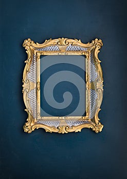 Old, victorian, gilded, decorative frame on a green wall,