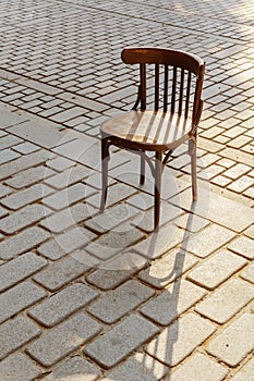 Old Viennese chair on the cobbles in the setting sun