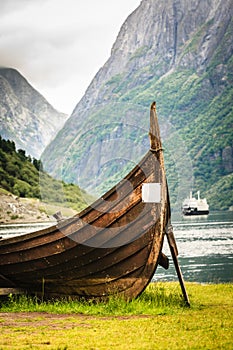 Old viking boat and ferryboat in norwegian fjord