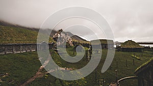 Old viking village in iceland with foggy hill. old wooden buildings covered in grass