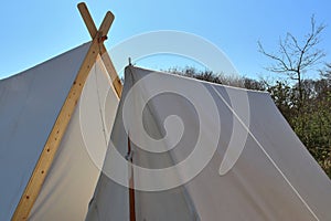 Old vikings tent made of cloth and wood in front of a blue sky