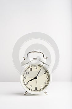 Old vintage alarm clock on the white background.