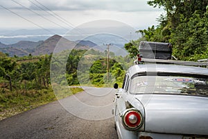 Old vintage American car on a road outside Trinidad