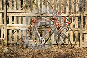 Old vintage bicycle against a wooden fence