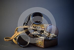Old vintage Binoculars with treasure. Black background. Close up.