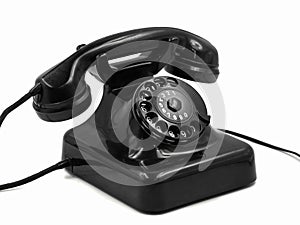 Old vintage black rotary dial telephone isolated on white background, retro bakelite phone