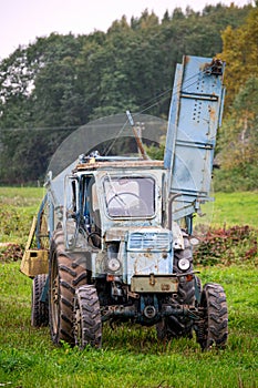 Old vintage blue tractor in the countryside.