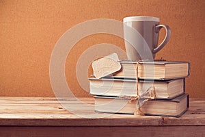 Old vintage books with cup and price tag on wooden table. Back to school concept