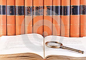 Old vintage books and loupe close-up as a background