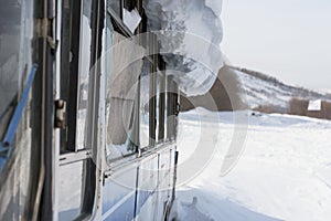 Old vintage bus covered with winter snow at mountains background