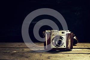 Old Vintage Camera on Dark Wooden Background. Horizontal with Co