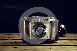 Old Vintage Camera on Dark Wooden Background. Horizontal with Co