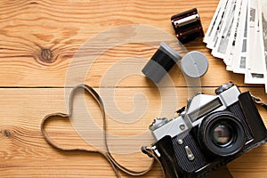 Old vintage camera, film and photos on wooden table