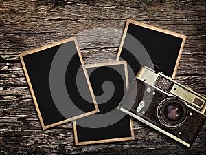 Old vintage camera and photos on a wooden background