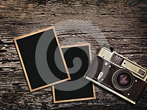 Old vintage camera and photos on a wooden background