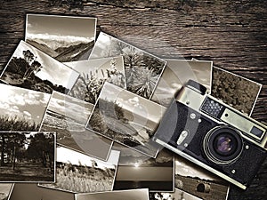 Old vintage camera and photos on a wooden background