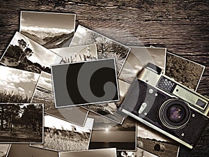 Old vintage camera and photos on a wooden background