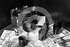 Old vintage camera, rolls of film, old photos. Tilted view, floating focus, fine grain film