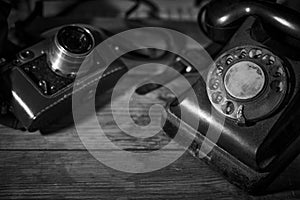 Old vintage camera and a telephone on a desk, cinematic noir scene