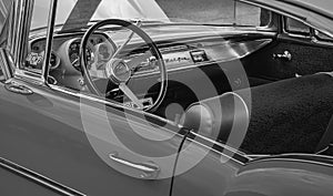 Old vintage interior of a car with steering wheel and cockpit. Retro styled image of an old car radio inside classic car