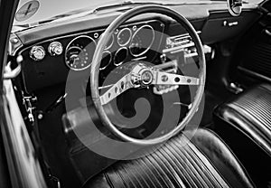 Old vintage car steering wheel and cockpit. Retro styled image of an old car radio inside classic car Chevrolet