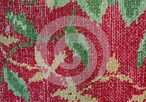 Old vintage carpet pattern background. Flowers with green leaves fabrics on red background. Authentic cloth textile