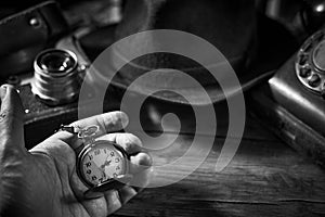 Old vintage cinematic noir scene, detective`s desk with a hat, telephone, camera, portable cassette recorder, and whisky