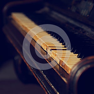 Old vintage classical piano on dark background. Closeup toned re
