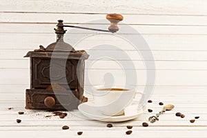 Old vintage coffee grinder with ceramic cup