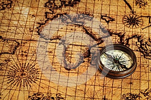 Old vintage compass on ancient map