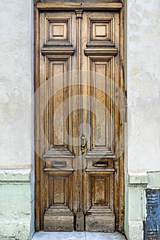 Old vintage door. Antique wooden door background with lock and handle on architecture facade home.