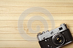 Old vintage film camera on wooden background, top view