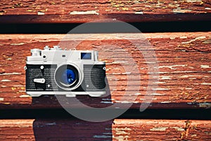 Old vintage film photo camera lying on wooden background. Copy space. Top view