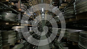 Old vintage film reel, film tapes in cases lying on archive shelfs. Dolly shot.