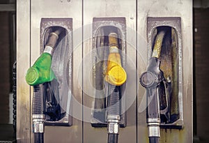 Old vintage gas station with three nozzles in green, yellow and black colors, closeup