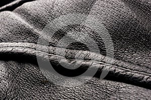 Old vintage genuine soft black leather texture background, top layer with pores and scratches, macro, close-up