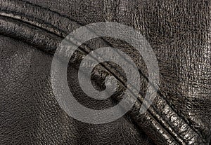 Old vintage genuine soft black leather texture background, top layer with pores and scratches, macro, close-up