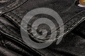 Old vintage genuine soft black leather texture background, top layer with pores and scratches, macro, close-up