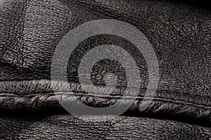 Old vintage genuine soft black leather texture background, top layer with pores and scratches, macro, close-up