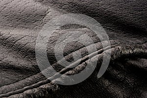 Old vintage genuine soft black leather texture background, top layer with pores and scratches, macro, close-up