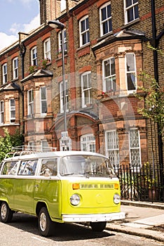 Old vintage green van parked in a street with victorian houses