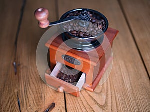Old vintage grinder with roasted coffee beans and grind coffee