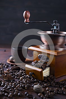 Old vintage grinder with roasted coffee beans and grind coffee on stone background.