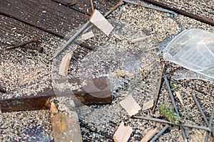 Old vintage hammer, wood saw, nails, safety glasses and sawdust on a wooden background, close-up, selective focus