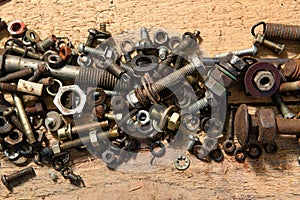 Old vintage hand tools - set of screws and nuts on a wooden background