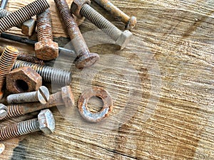 Old vintage hand tools - set of screws and nuts on a wooden background. A lot of old rustic screws